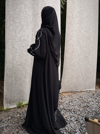 Back view of the black abaya and draped matching hijab, showing the full-length silhouette. 4